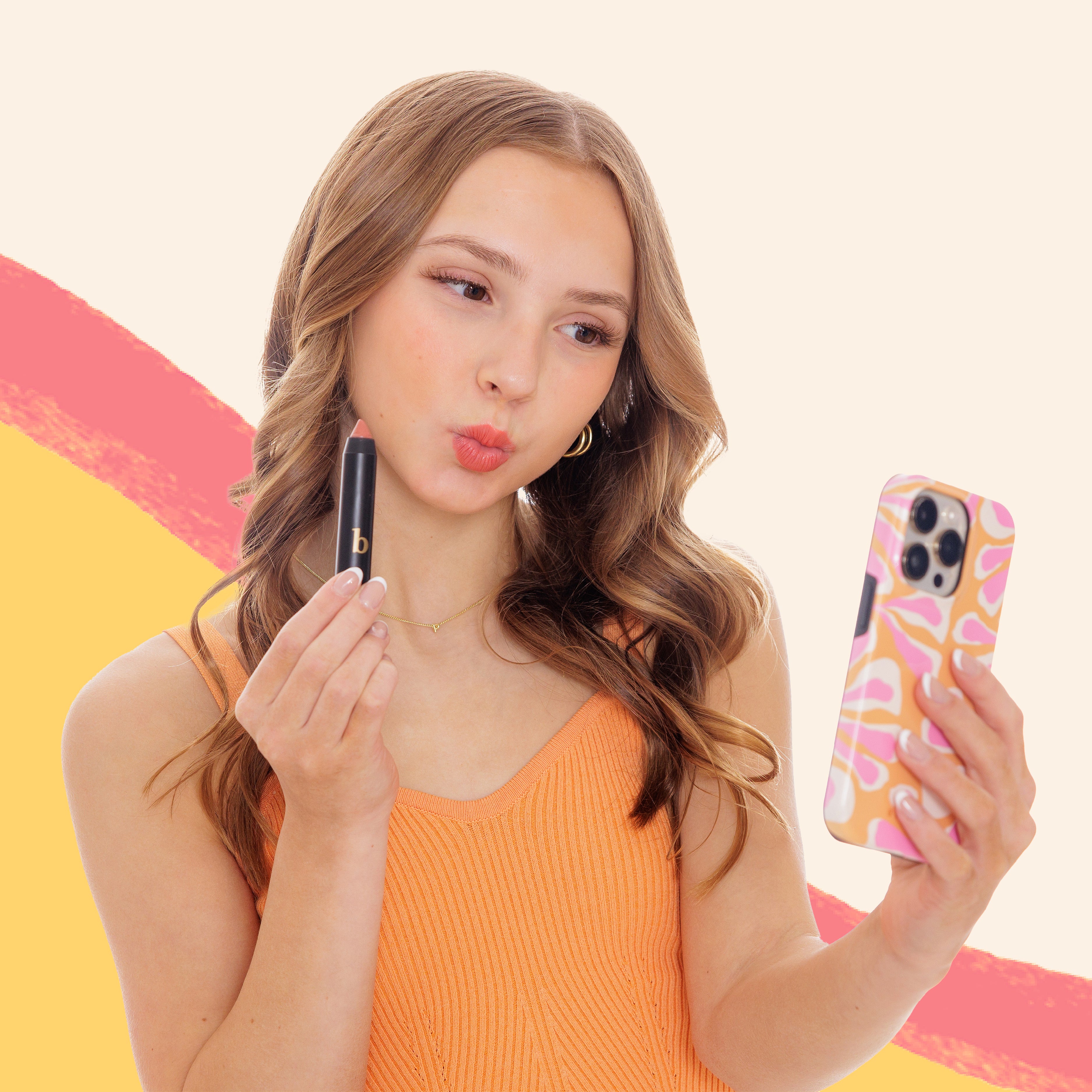 girl putting on lipstick with yellow and pink swirl as a background.